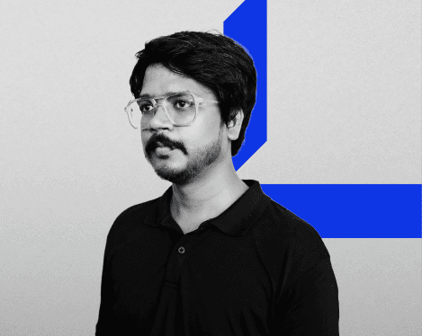 A woman with straight blonde hair wearing a light colored sweater looks away.