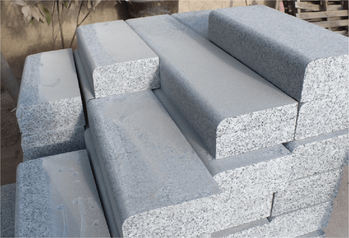 Stacked granite kerbstones processed by Dinosaw Kerbstone Cutting Machine, displaying smooth and uniform edges for quality finish.