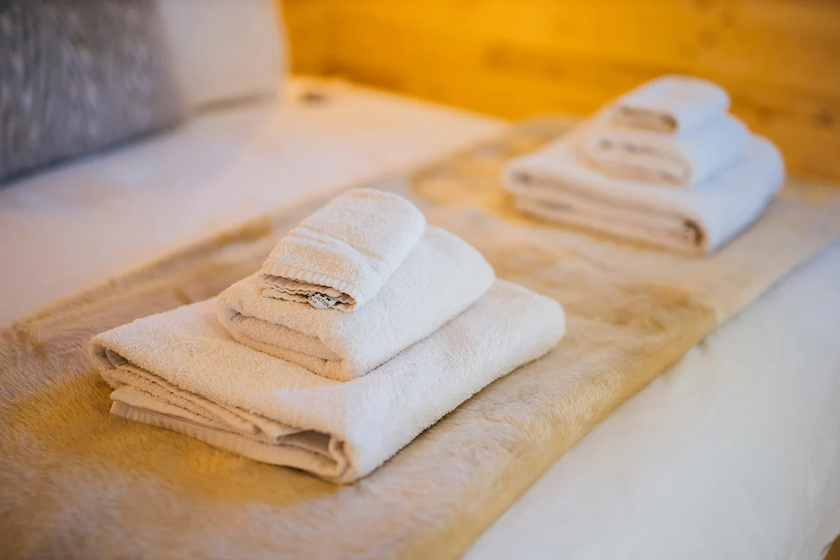 Folded towels arranged on a hotel bed.