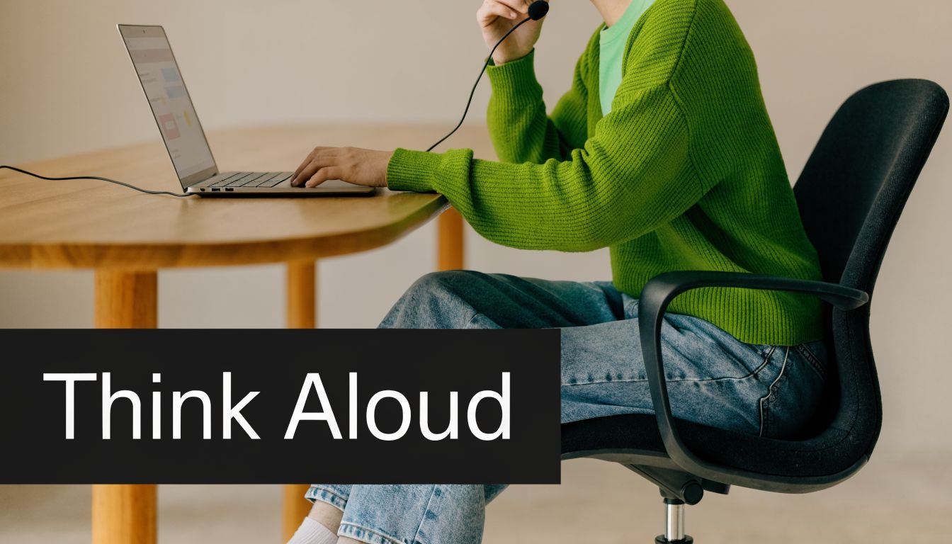 A person wearing a headset working on a laptop at a wooden table for usability testing