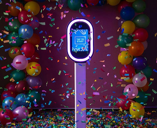 Foto van de photobooth in feestelijke omgeving, met confetti en ballonnen, verjaardag sfeer.