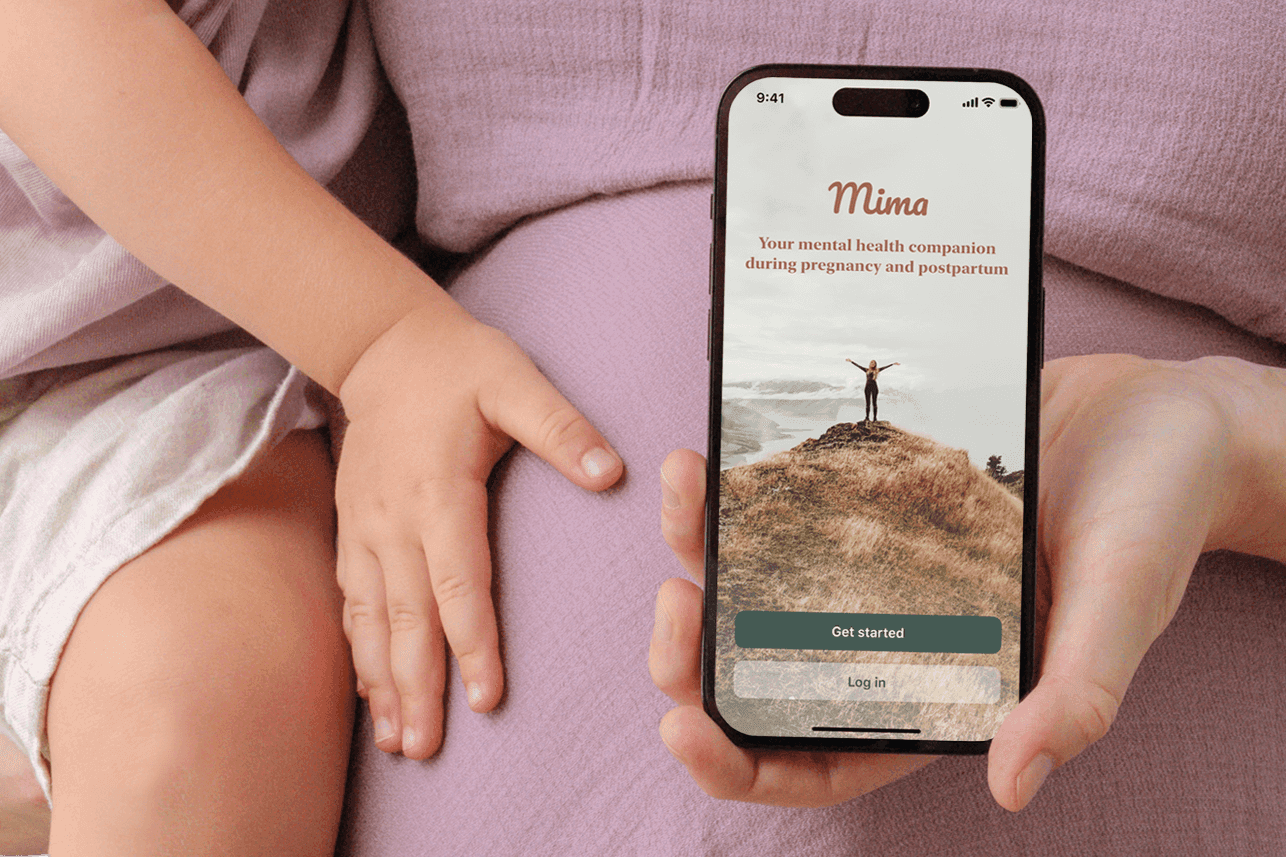 A pregnant woman with a child holding a phone that showcases the app Mima.