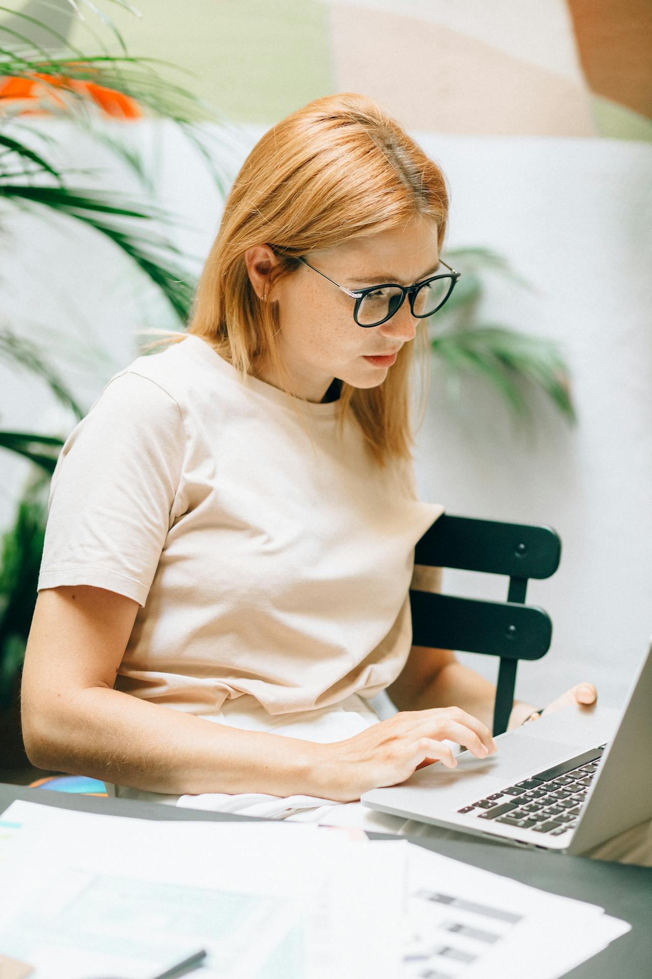 A Woman Wearing Eyeglasses Using a Laptop