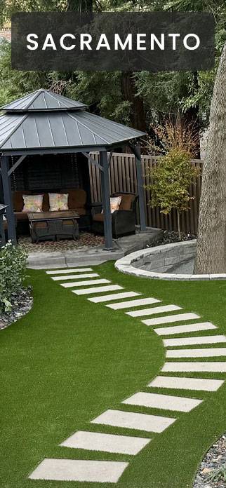 Artificial grass backyard in Sacramento with a curved concrete stepper path leading to a metal-roof gazebo.