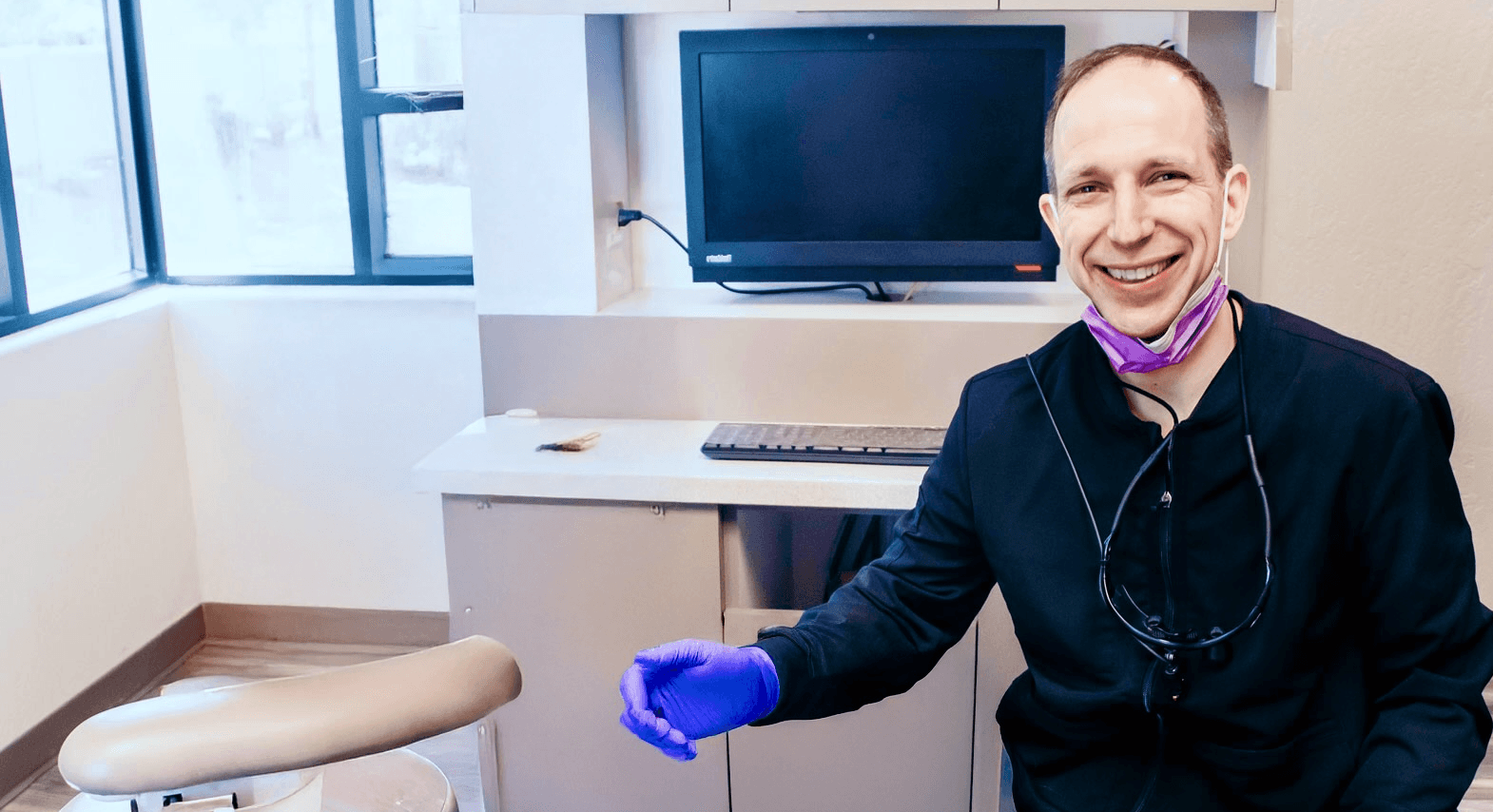 Doctor Gailey smiling while he helps a patient