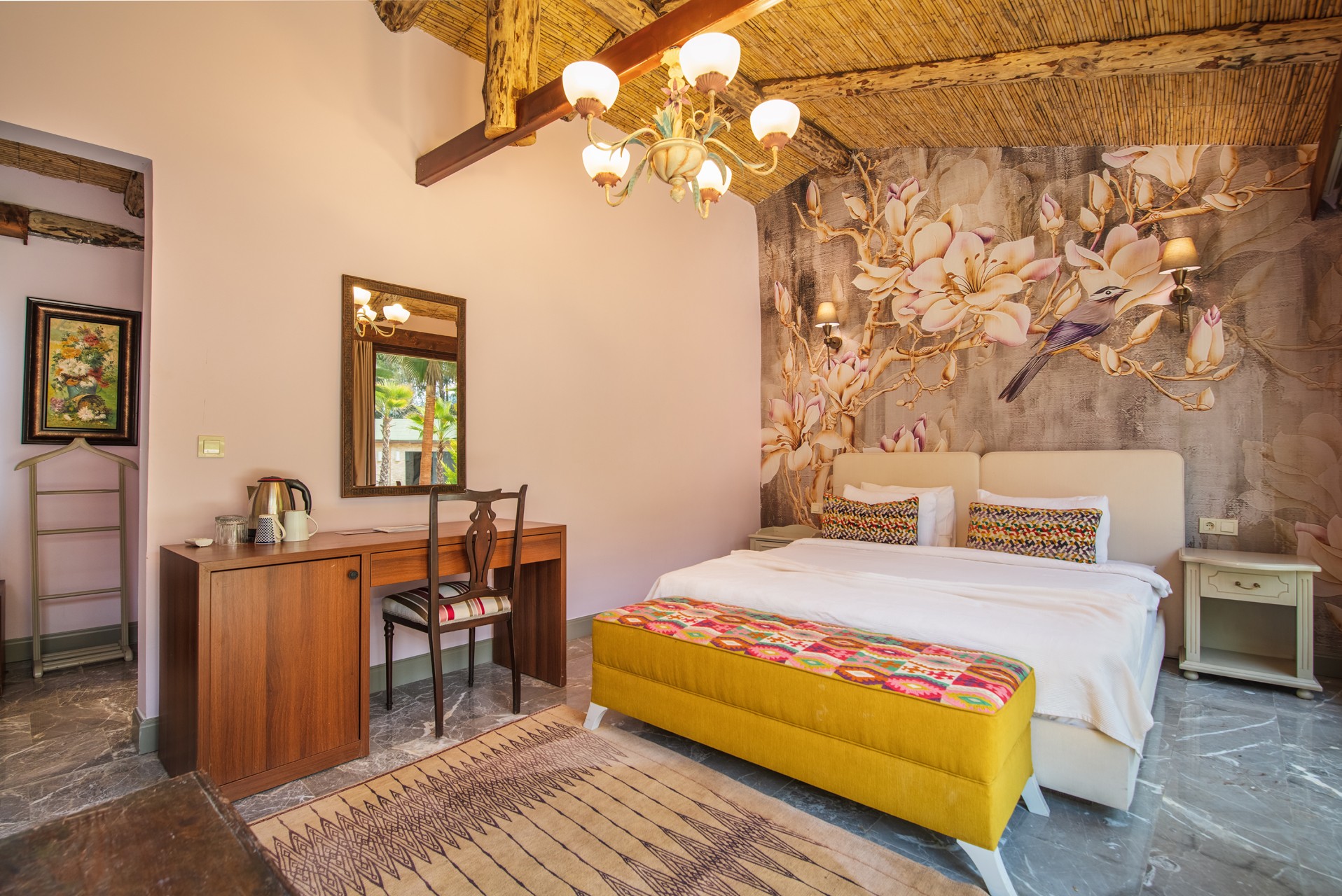 crisp white bedding, layered pillows, a plush bench at the foot of the bed