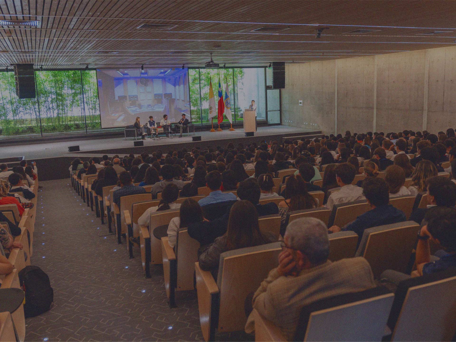 Jóvenes participan de un panel en un escenario frente a cientos de escolares en el Encuentro de Líderes Jóvenes de IdeaPaís.