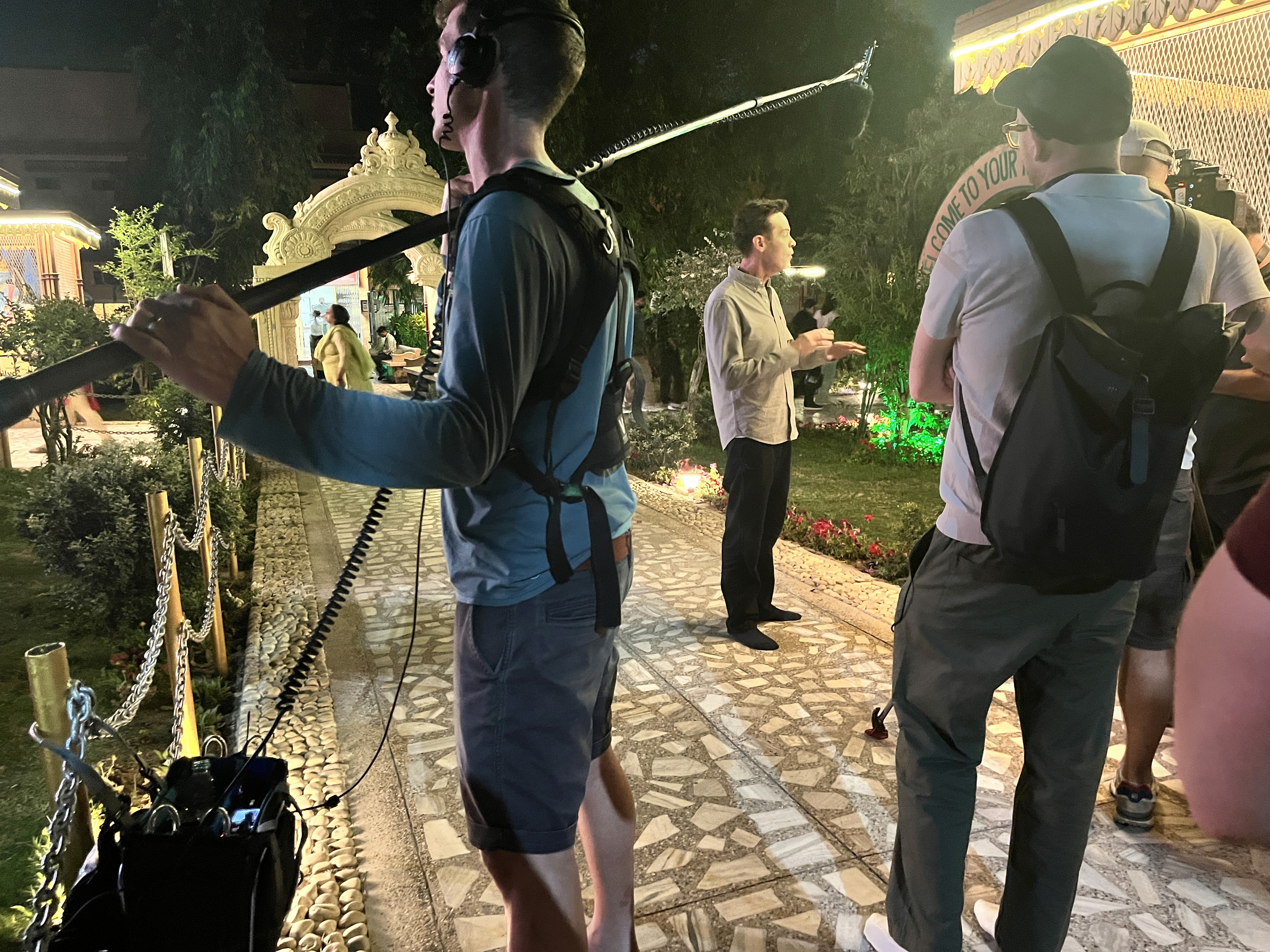 Minimal turntable with a vinyl record on a cream and wood base against a soft gray background.