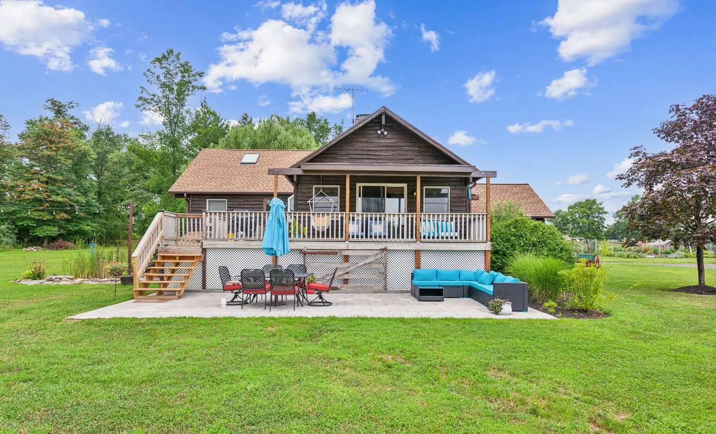 Rear of the farmhouse with deck and patio across the lawn at Rocking Horse Acres, Bucks County, PA