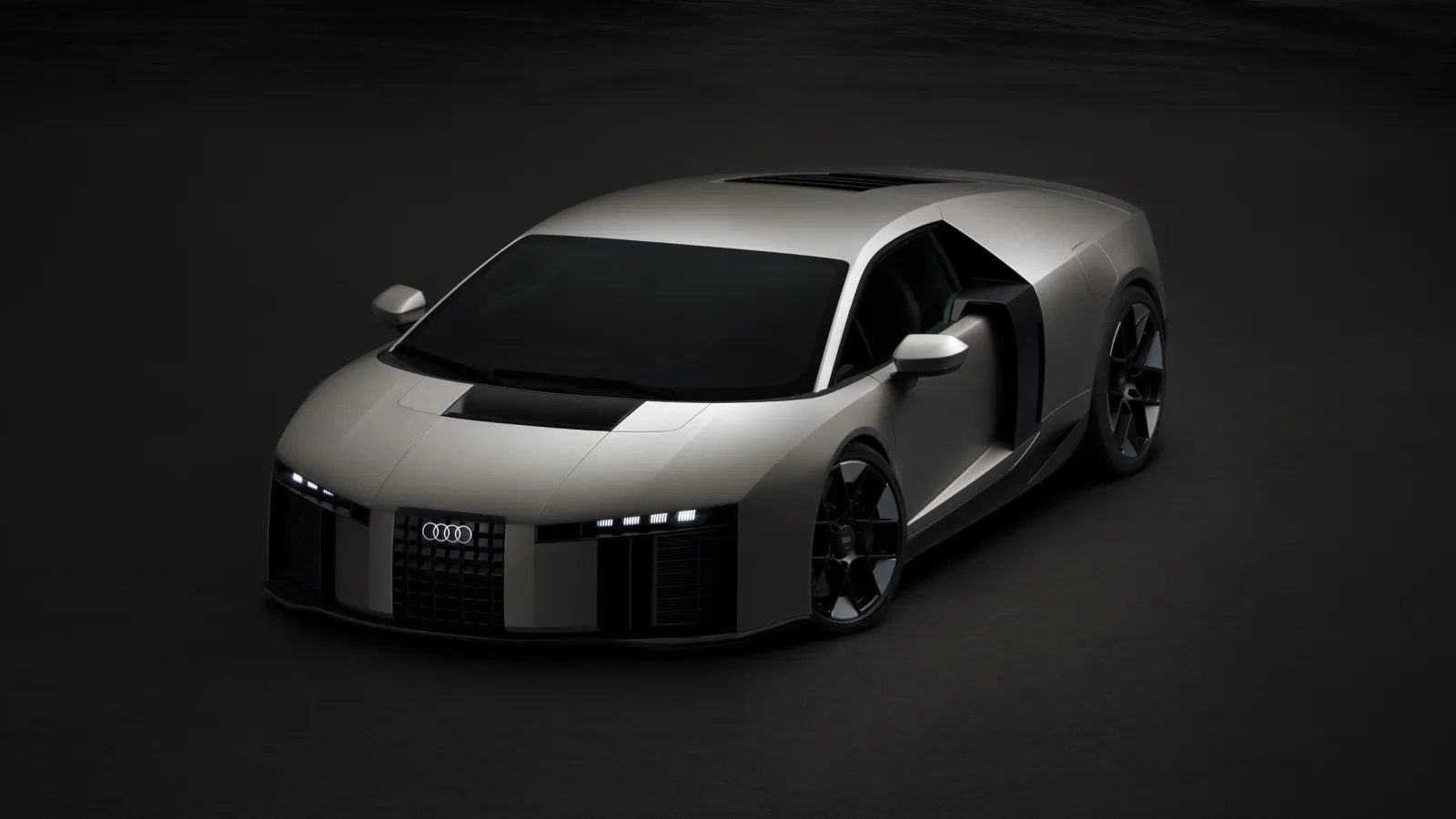 A sleek, futuristic silver sports car with a low profile and angular design is shown against a dark background, featuring distinctive LED headlights and a prominent grille adorned with the Audi logo.