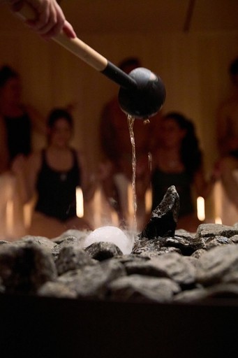 Photographie sous-marine capturant trois personnes immergées dans une eau claire et bleue, entourées de bulles tourbillonnantes et créant un mouvement dynamique.