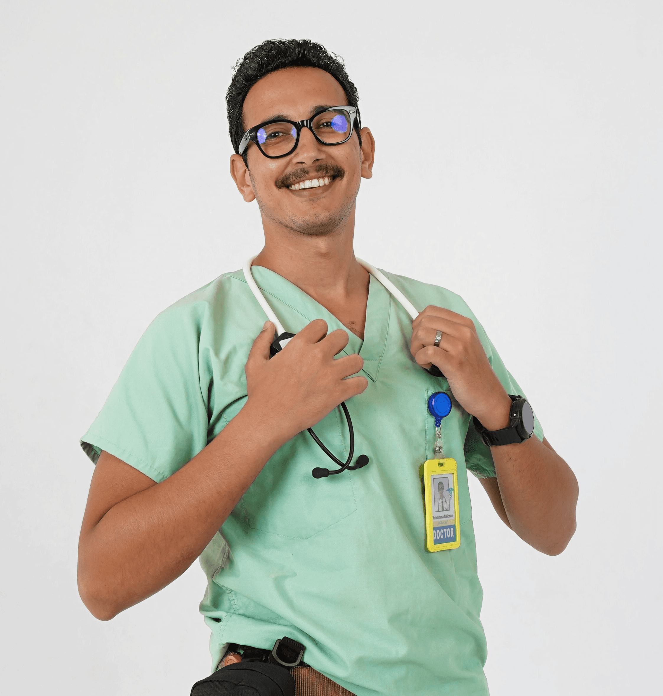 A man in a green scrub suit holding a toothbrush