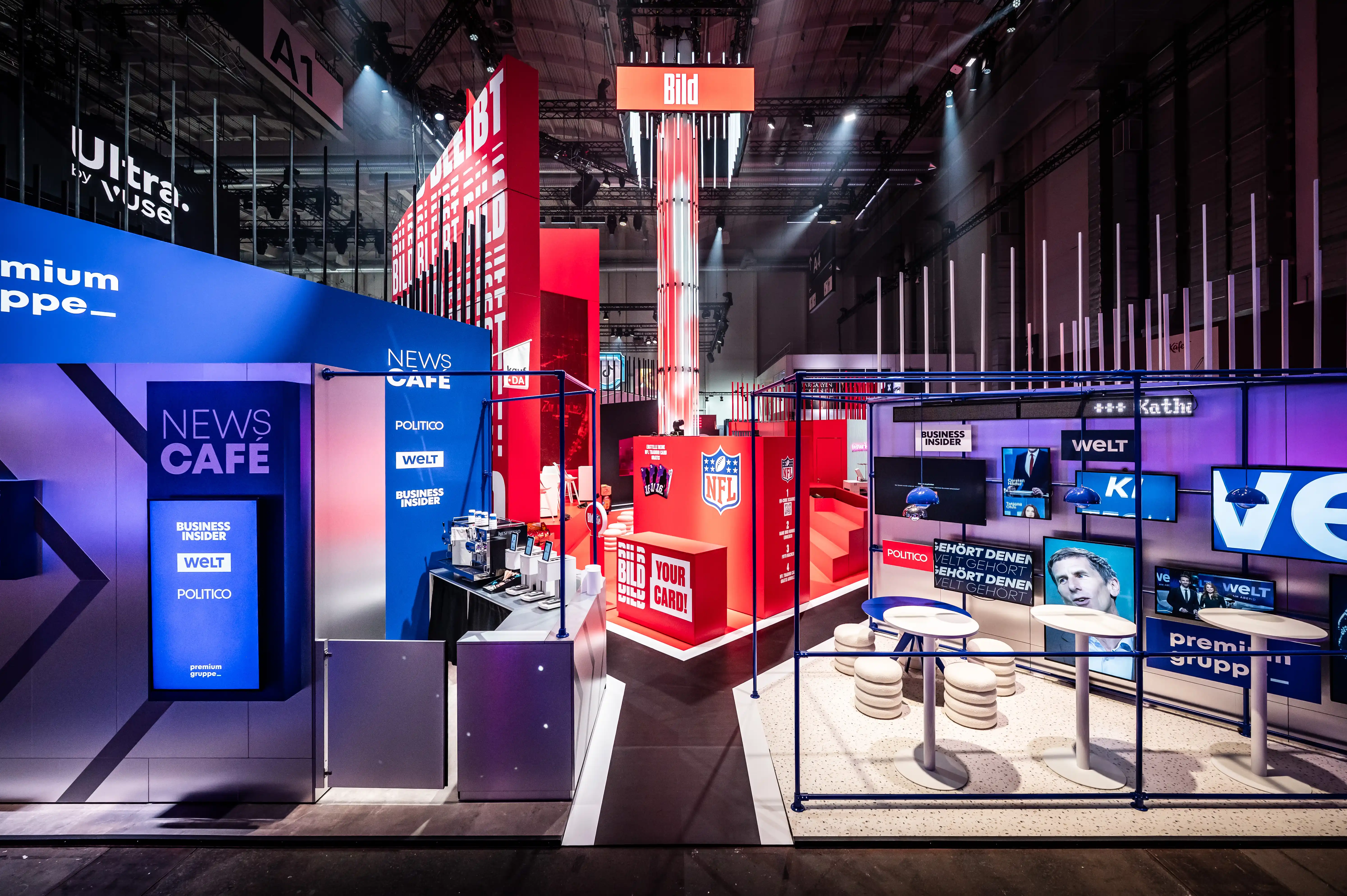 View across the Axel Springer booth with News Café, red Bild tower and Welt screens in the hall.