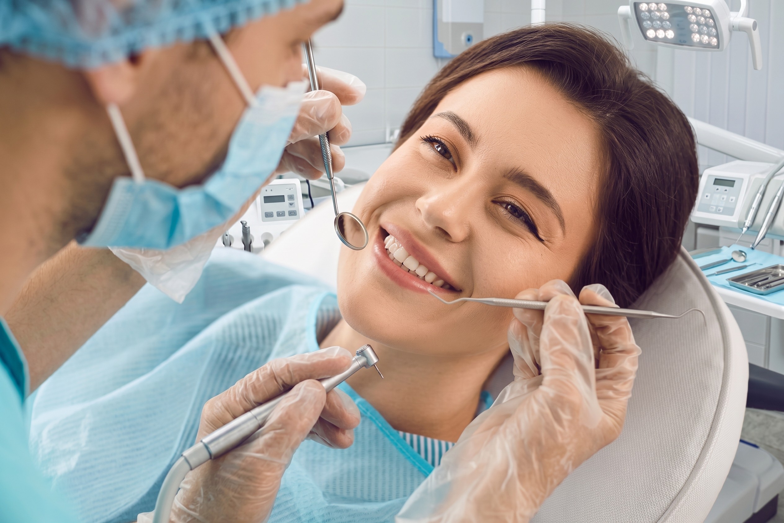 a man in a dentist's office holding a pair of scissors