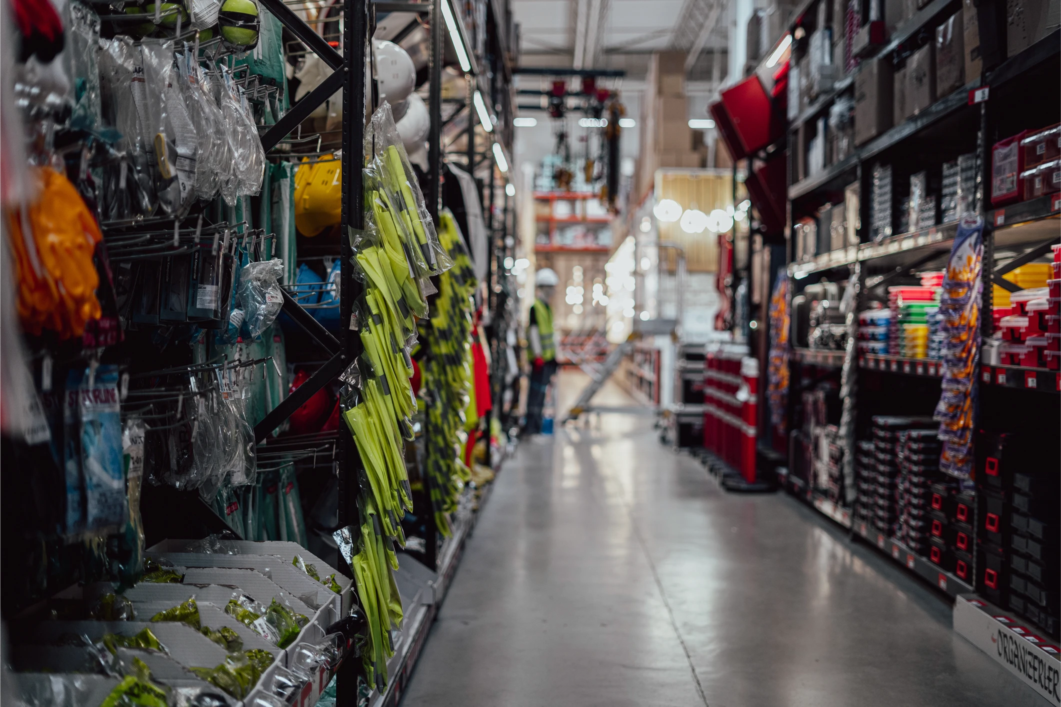 A vibrant market aisle filled with colorful flowers and decor, leading into a bright, bustling area.