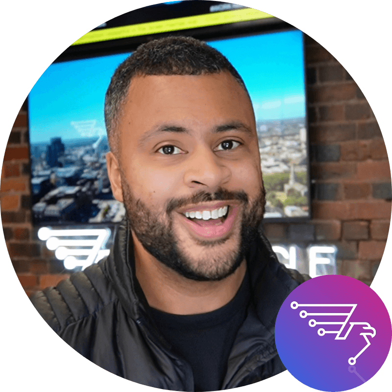 A woman with short curly hair wearing a black t-shirt looks into the camera.