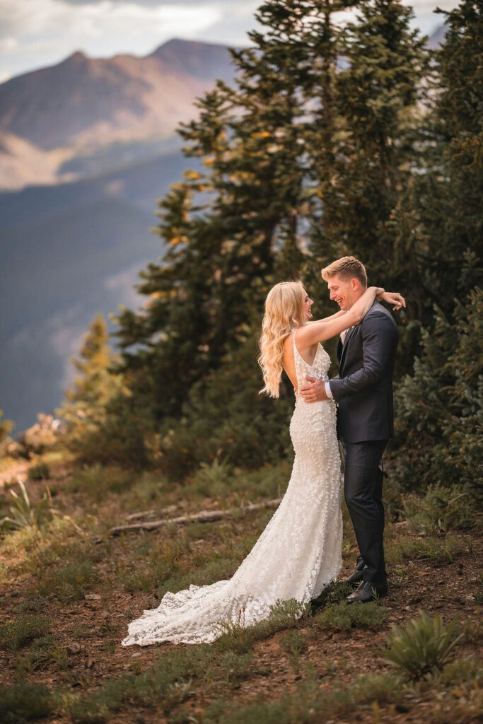 Newlyweds embracing on a mountainside