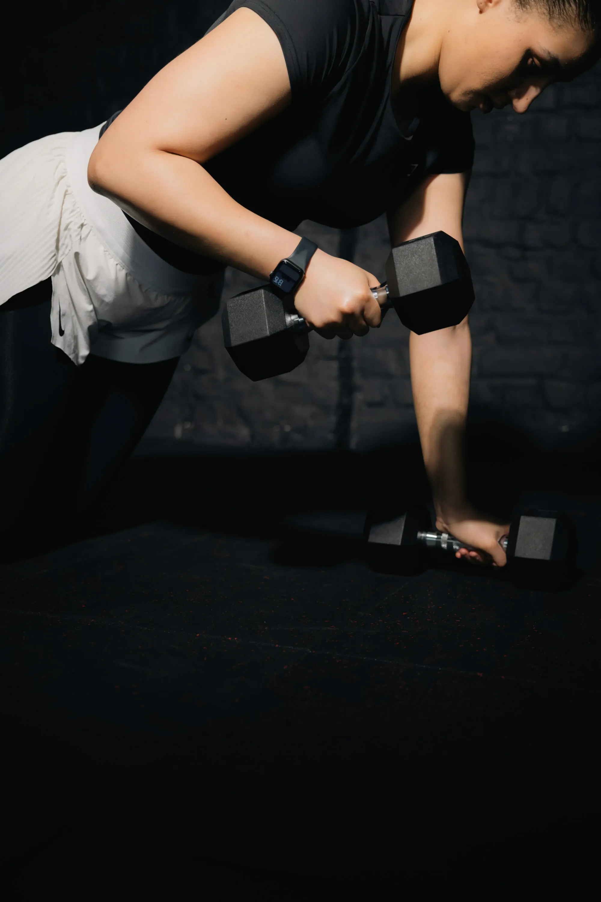 A woman lifting a barbell in a gym