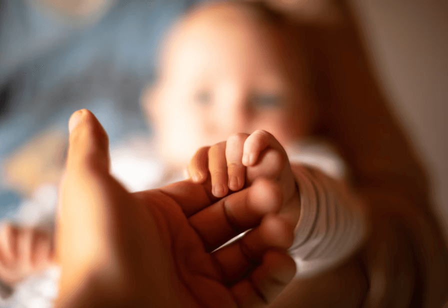 Baby holding parent's hand