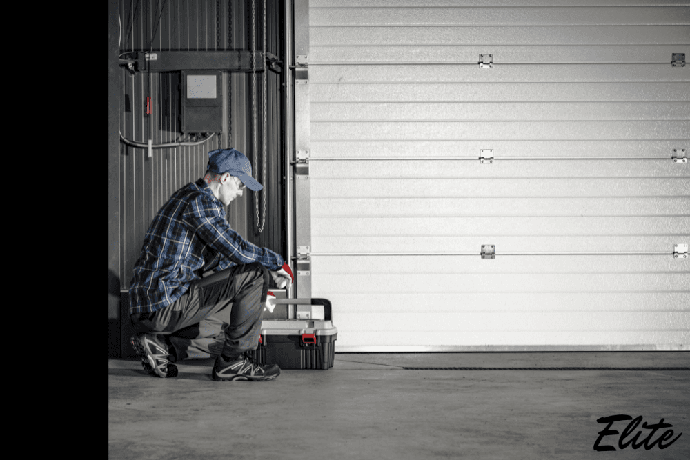 Elite Garage Door technician working on a garage door opener system in NWA.