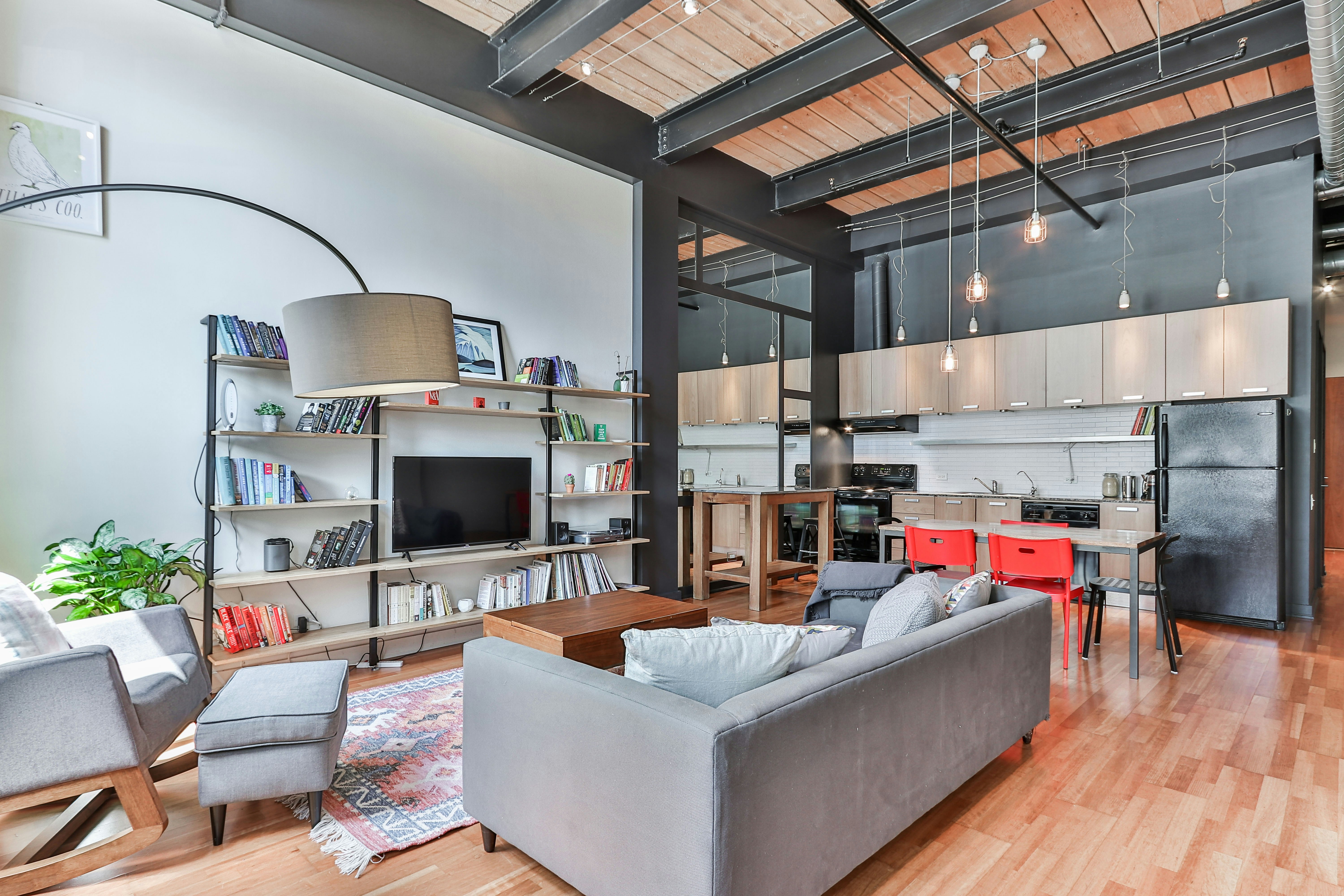 Industrial-style living room with exposed ductwork and brick walls.