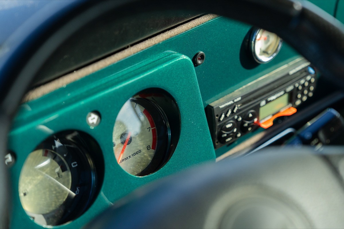 Close-up of a car dashboard featuring analog gauges and controls in an elegantly designed panel.