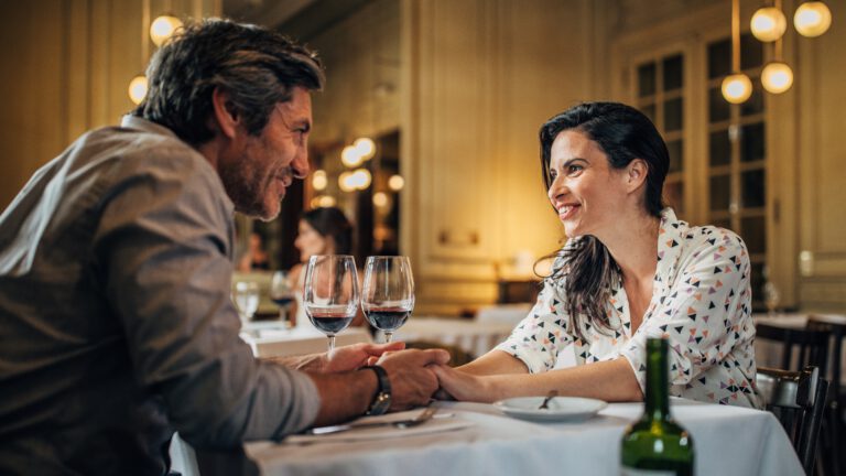 ein mann mit einer frau in einem restaurant, das paar hält händchen