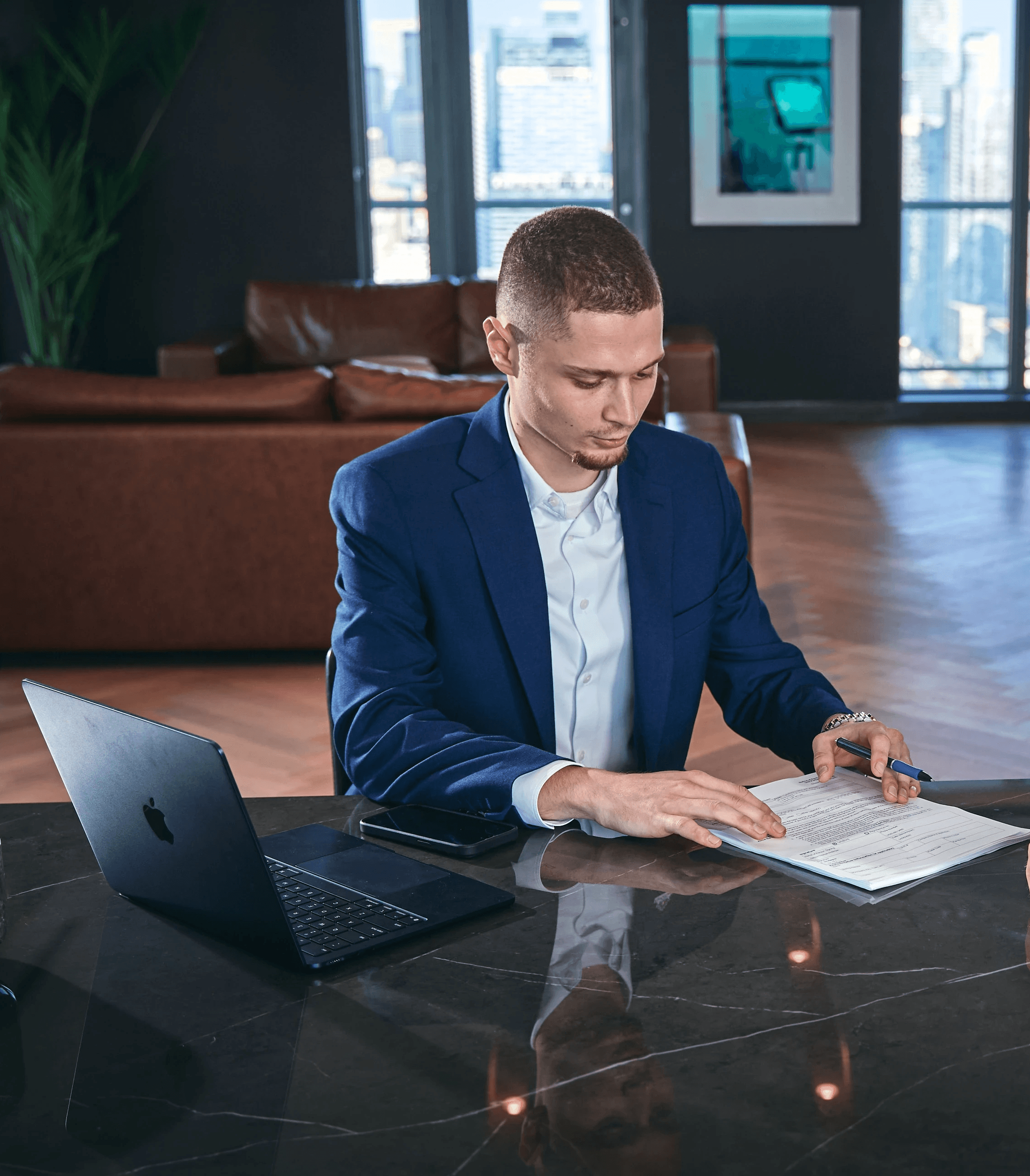 Modern glass skyscraper with angular architecture under a partly cloudy sky