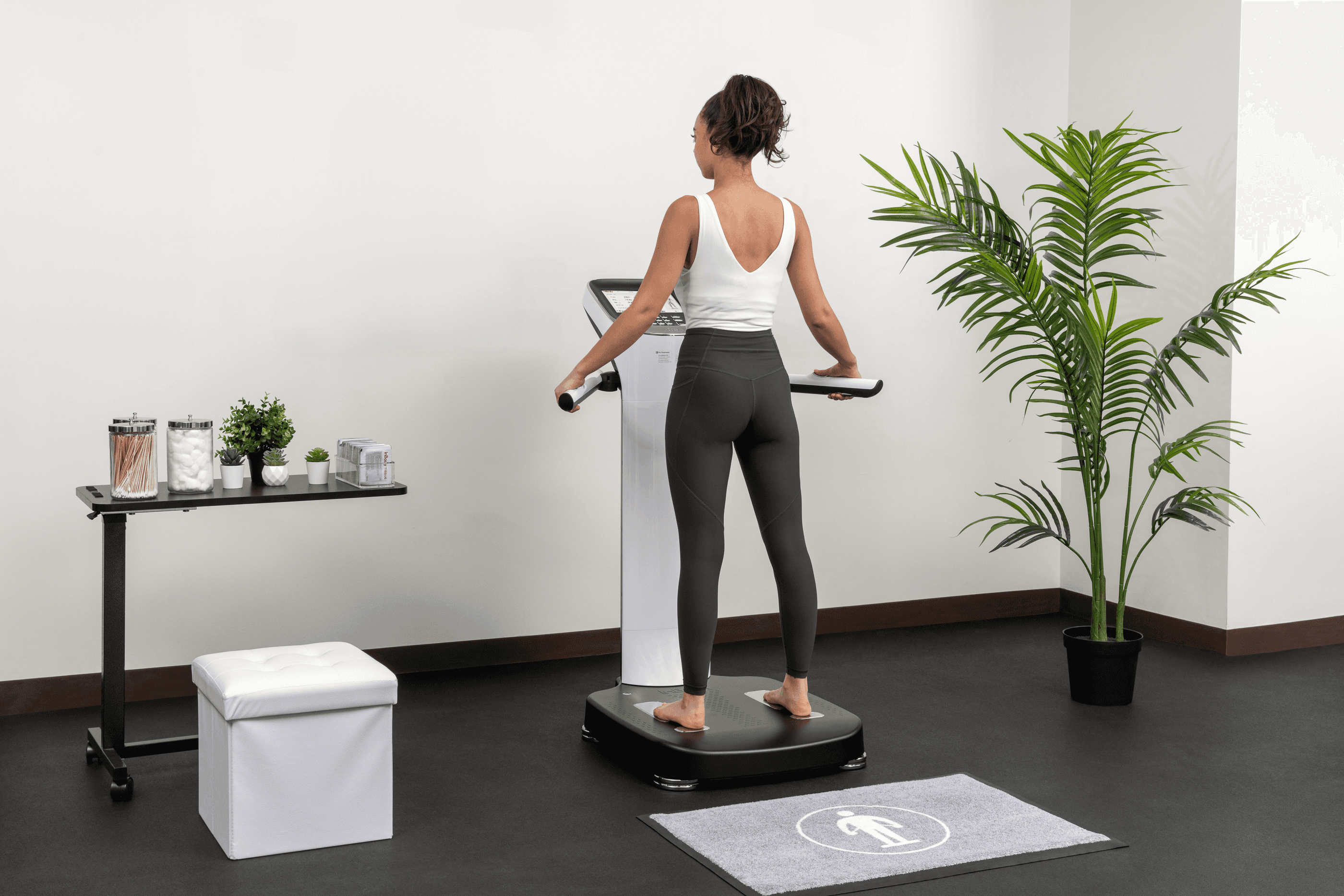 A woman standing on an InBody body composition analyzer for a professional body fat percentage test.