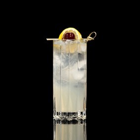 A closeup of a Vodka Collins drink against a dark background.