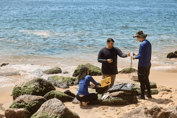 High school student conducting oceanography research with a PhD mentor reviewing data on marine ecosystems