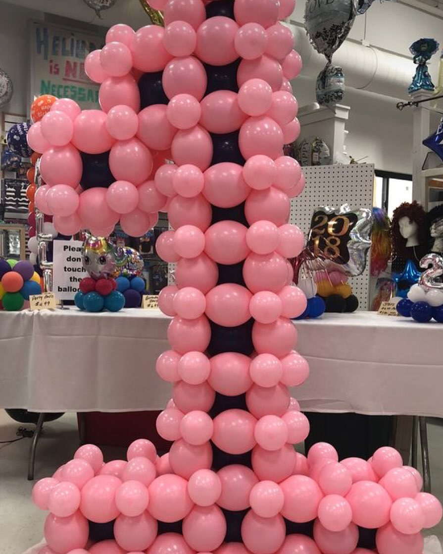 Large number one sculpture made of pink balloons for a first birthday celebration created by Be Bold Balloons