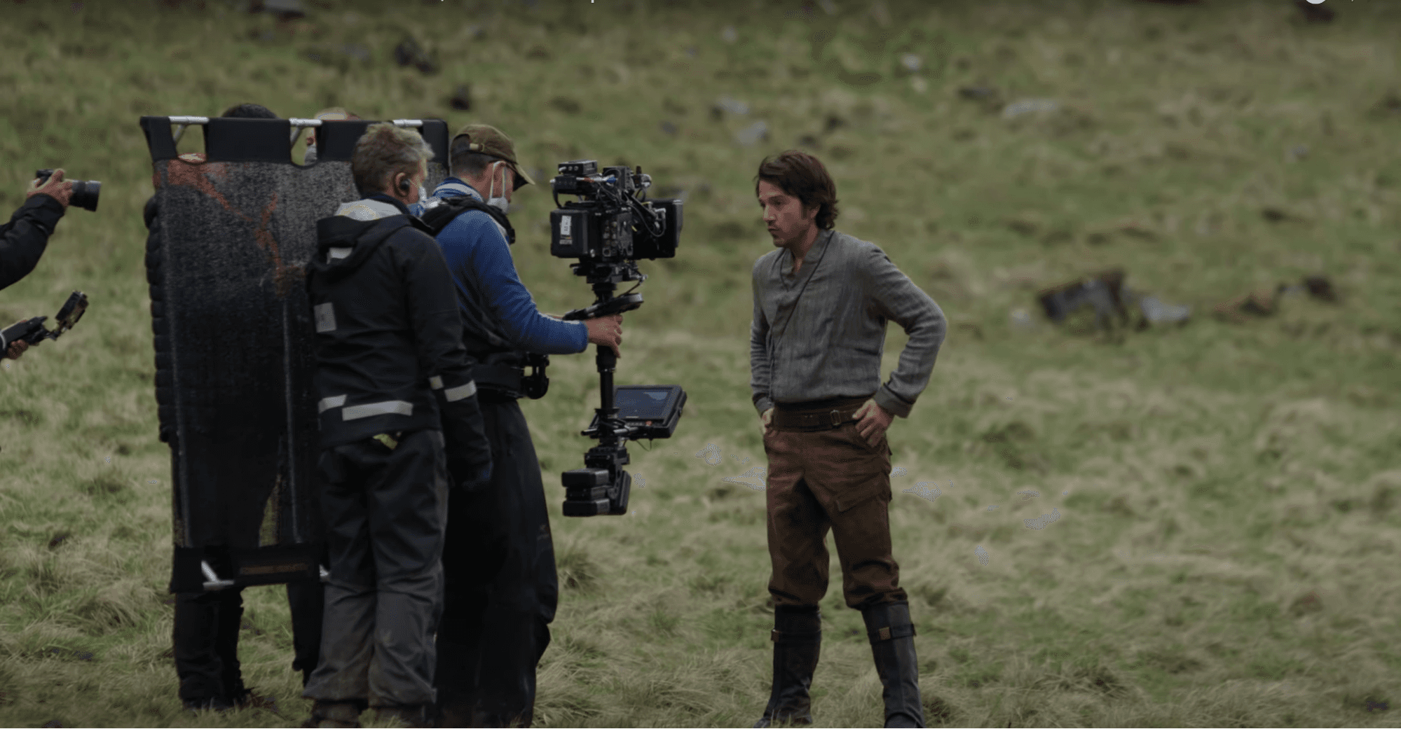 Diego Luna standing in front of a camera in the middle of a field