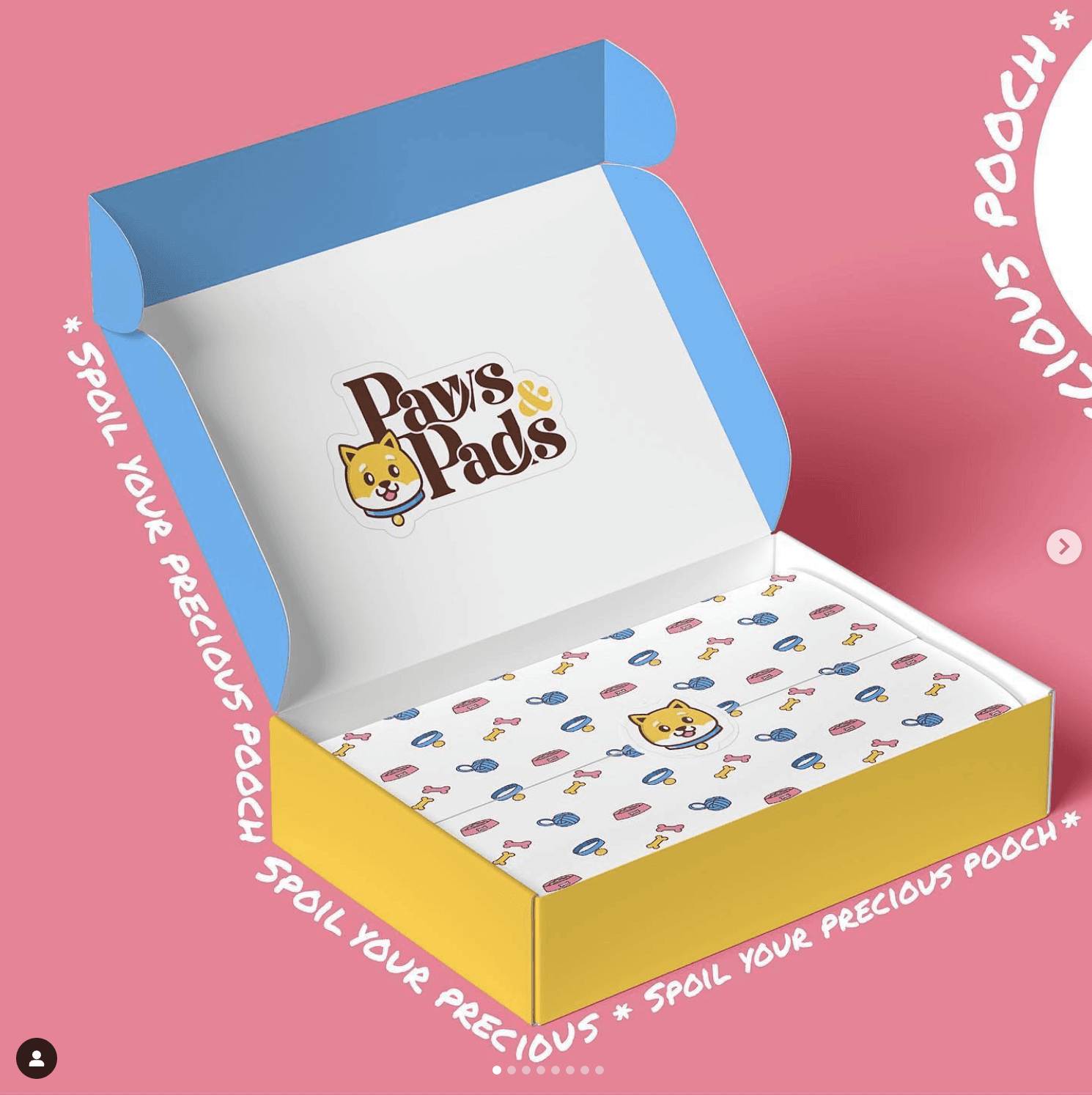 Open gift box with colorful interior, featuring a logo and a pattern of small dots, against a pink background.