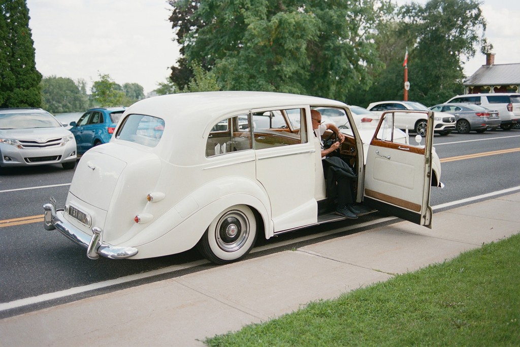 Classic white vintage wedding car parked roadside 