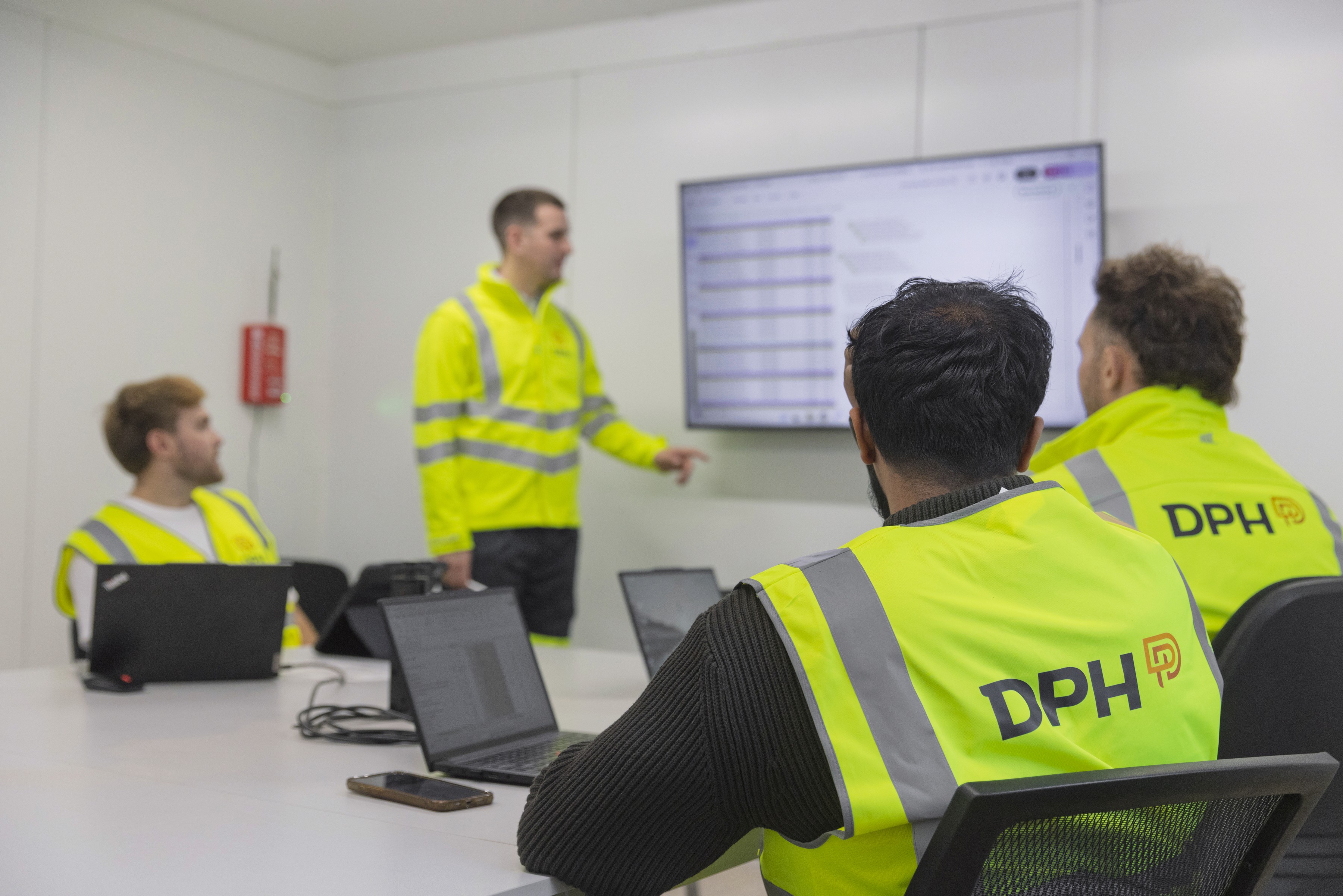 Modern building with a sleek glass facade and illuminated orange lighting, reflecting on a polished surface, creating a futuristic and elegant atmosphere