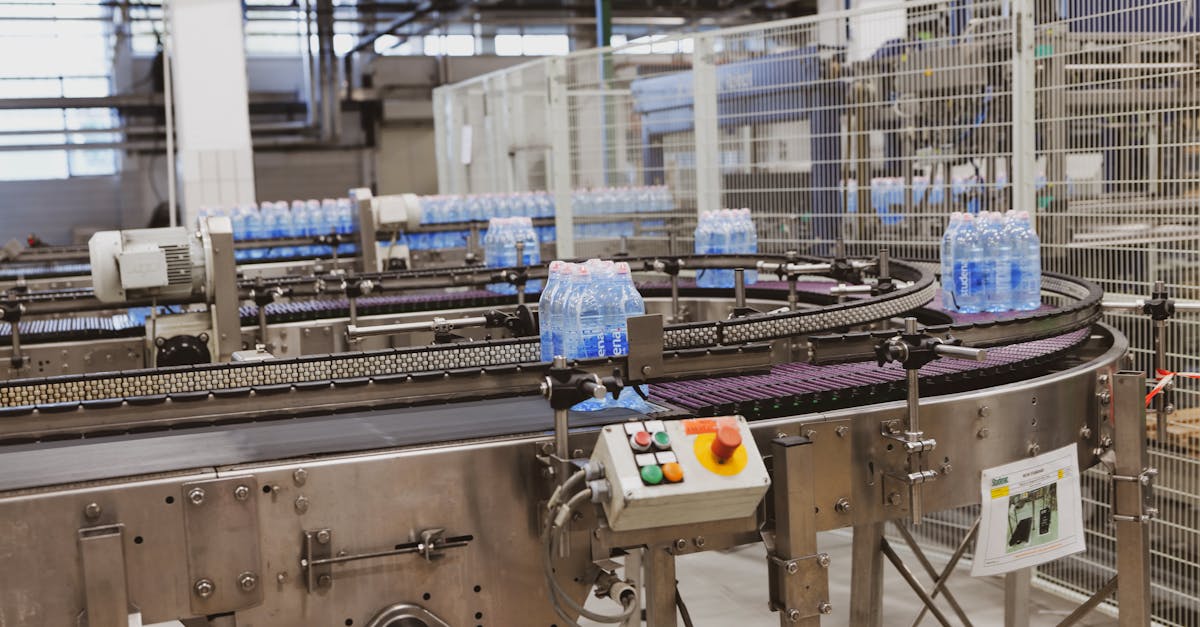 Water bottles being processed on an automated conveyor in a modern factory setting.
