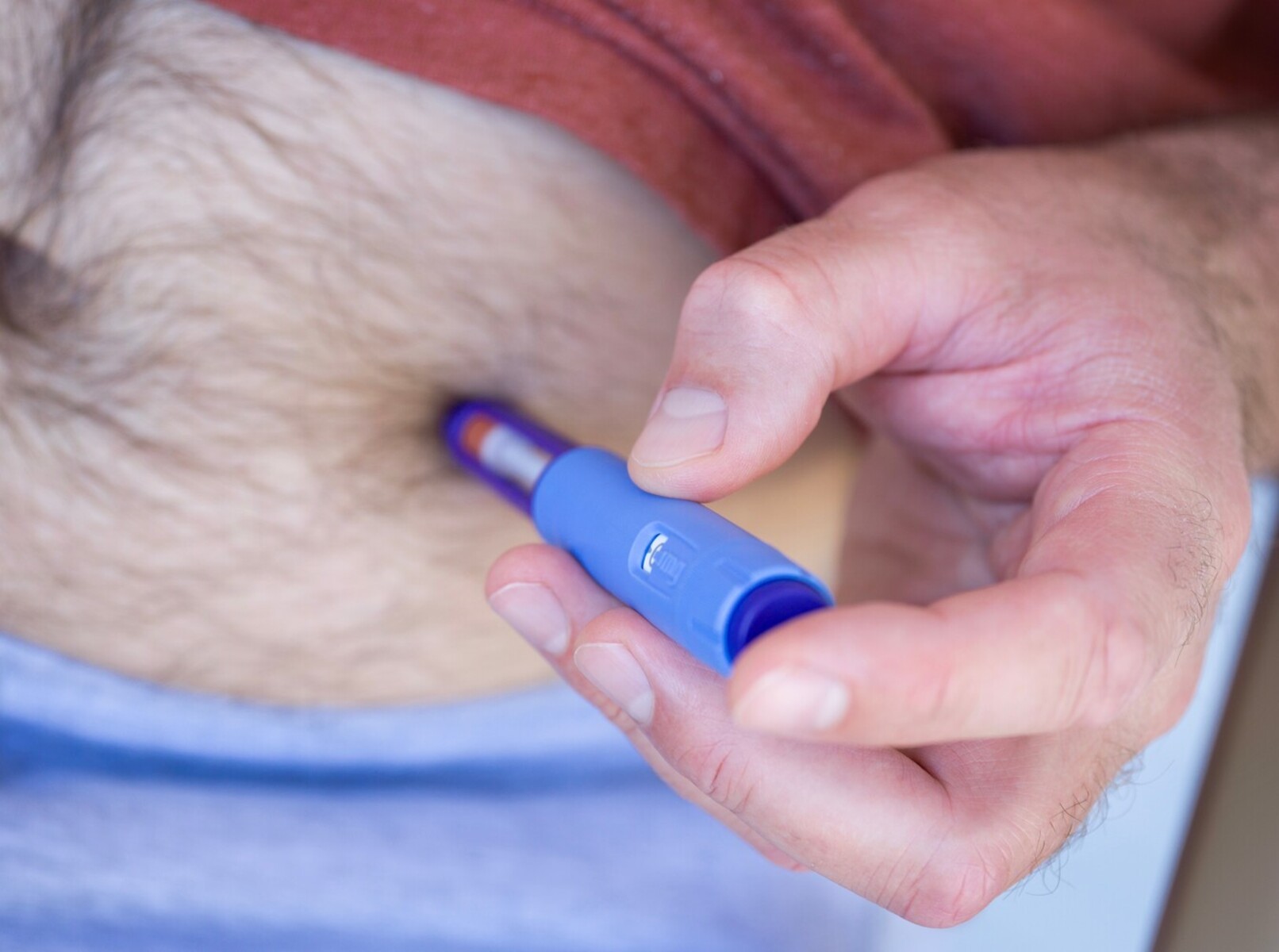 man using an injectable weight loss medication on his stomach