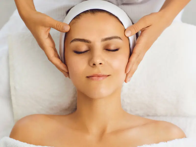A client relaxing during a facial treatment at a spa