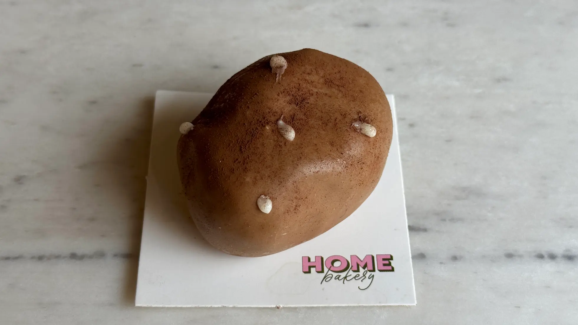 Potato-shaped mousse dessert with realistic brown texture and chocolate 'eyes