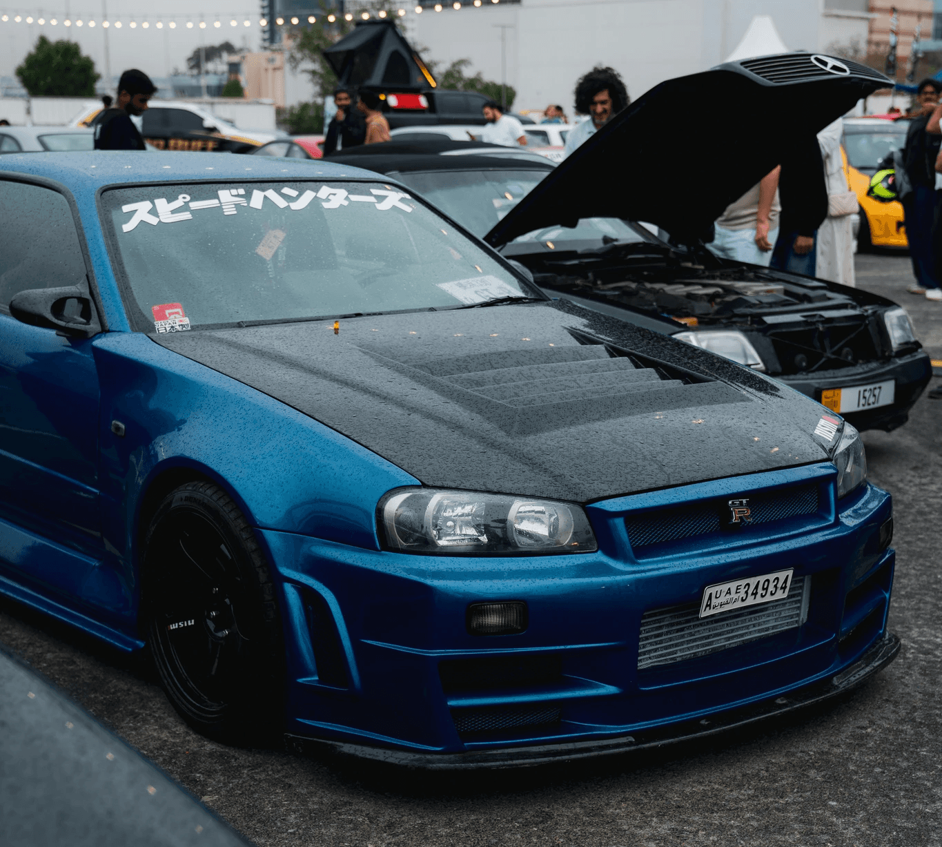Blue sports car with black hood at event