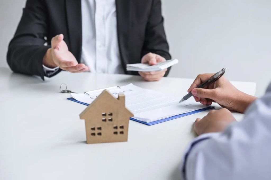 Mileage log for landlords supported by proper lease documentation as a tenant signs a rental agreement across from a property manager with a house model on the table