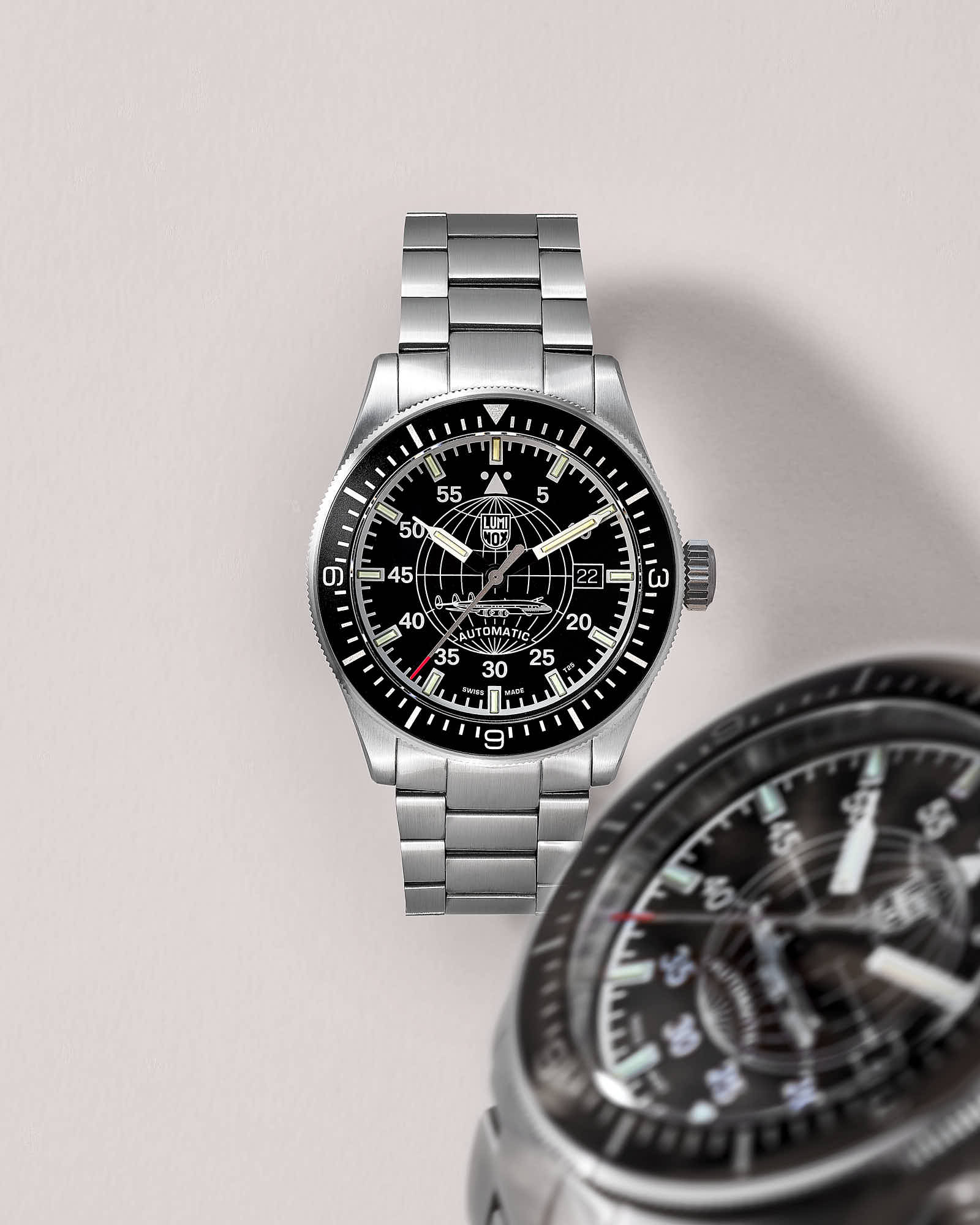 Silver wristwatch with black dial and stainless steel band displaying time and date.