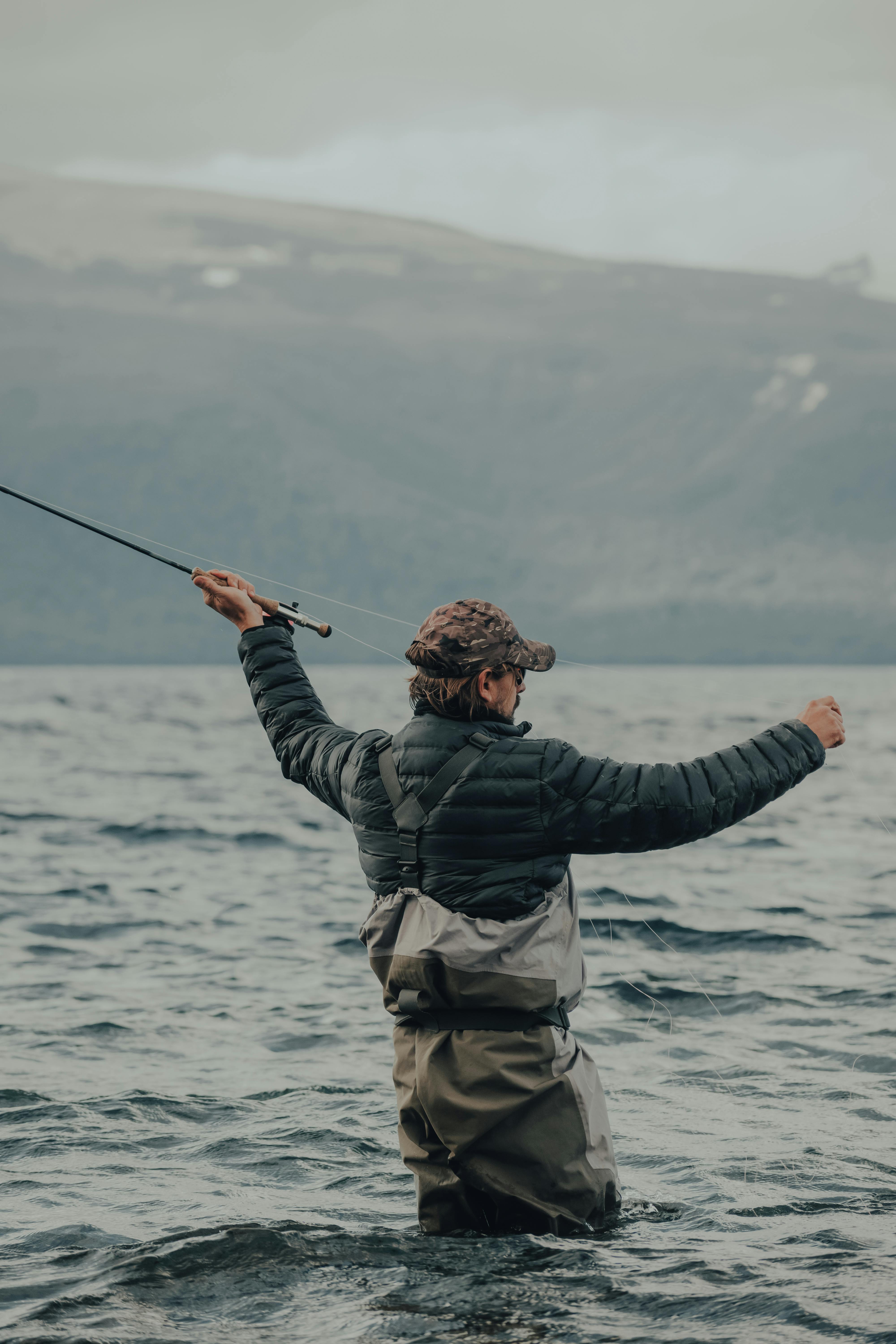Fly fishing in Italy on a peaceful river in Tuscany or Umbria, featuring a fisherman casting a dry fly for brown trout and wild trout in clear blue waters, surrounded by the scenic countryside. Perfect spot for alpine fishing adventures