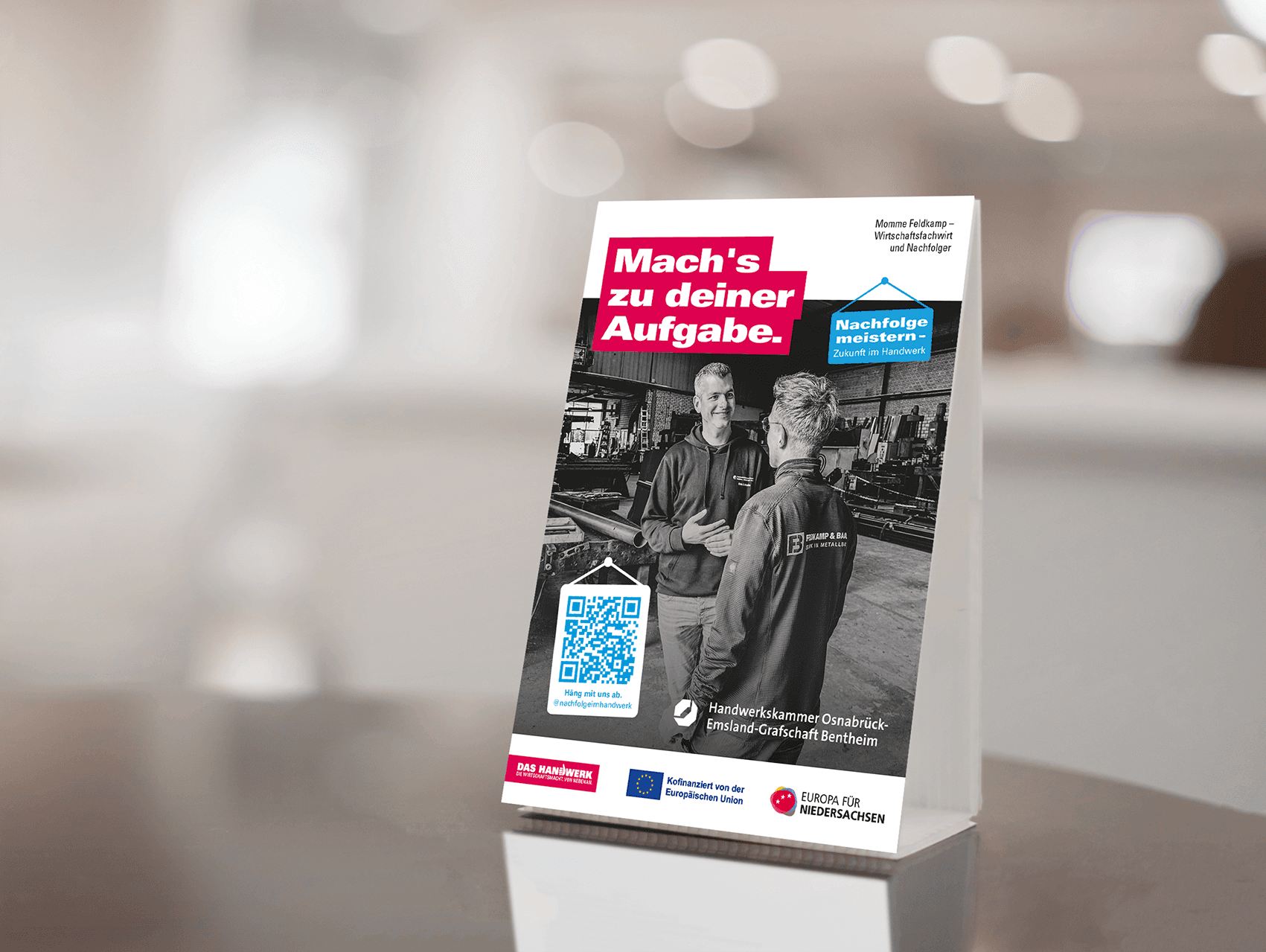 Infoständer "Mach's zu deiner Aufgabe" mit QR-Code und zwei Männern. Berufsorientierung