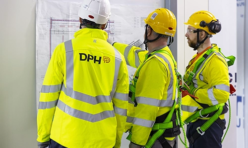 Modern glass buildings with illuminated facades and trees on a rainy day