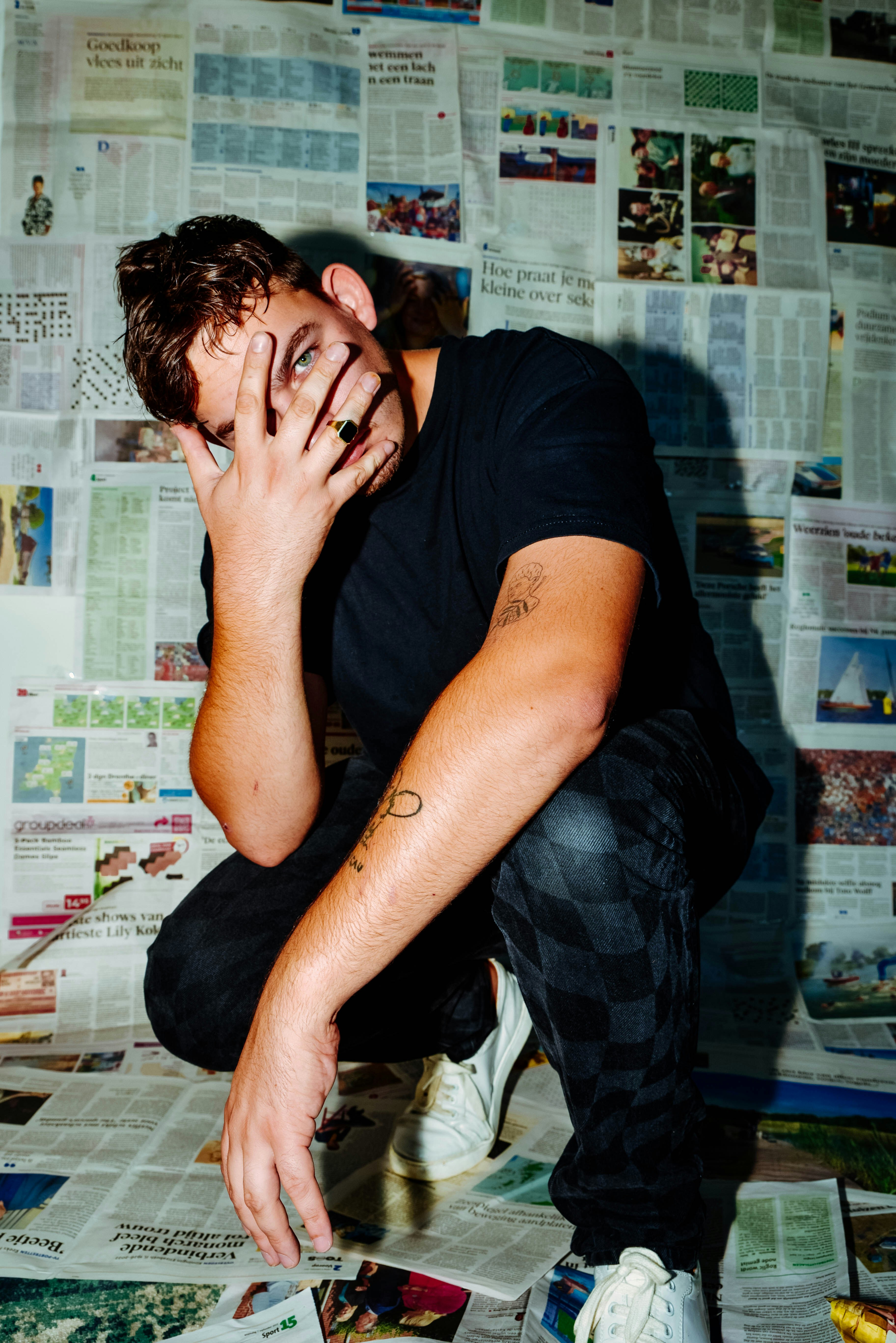 a man sitting on a table with his hand on his face