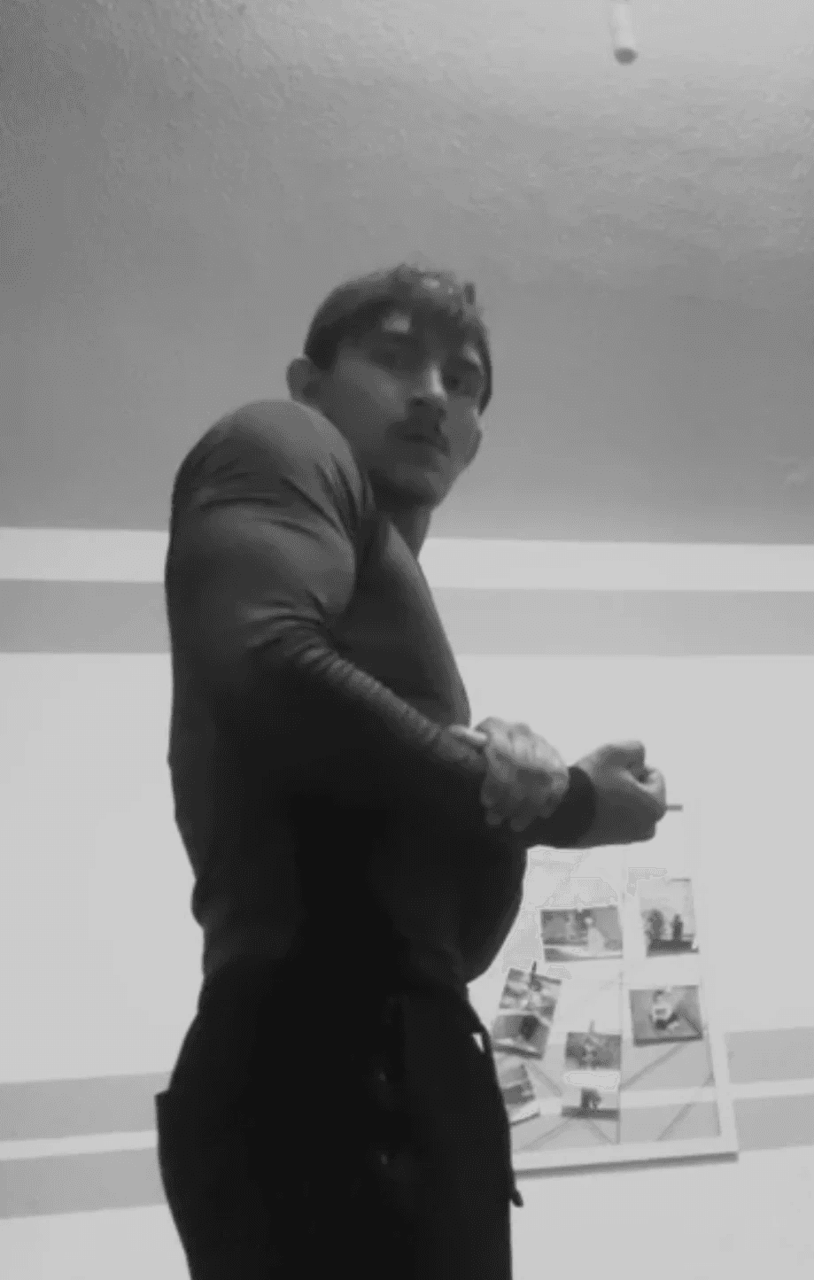 greyscale photo of woman in bralette inside room