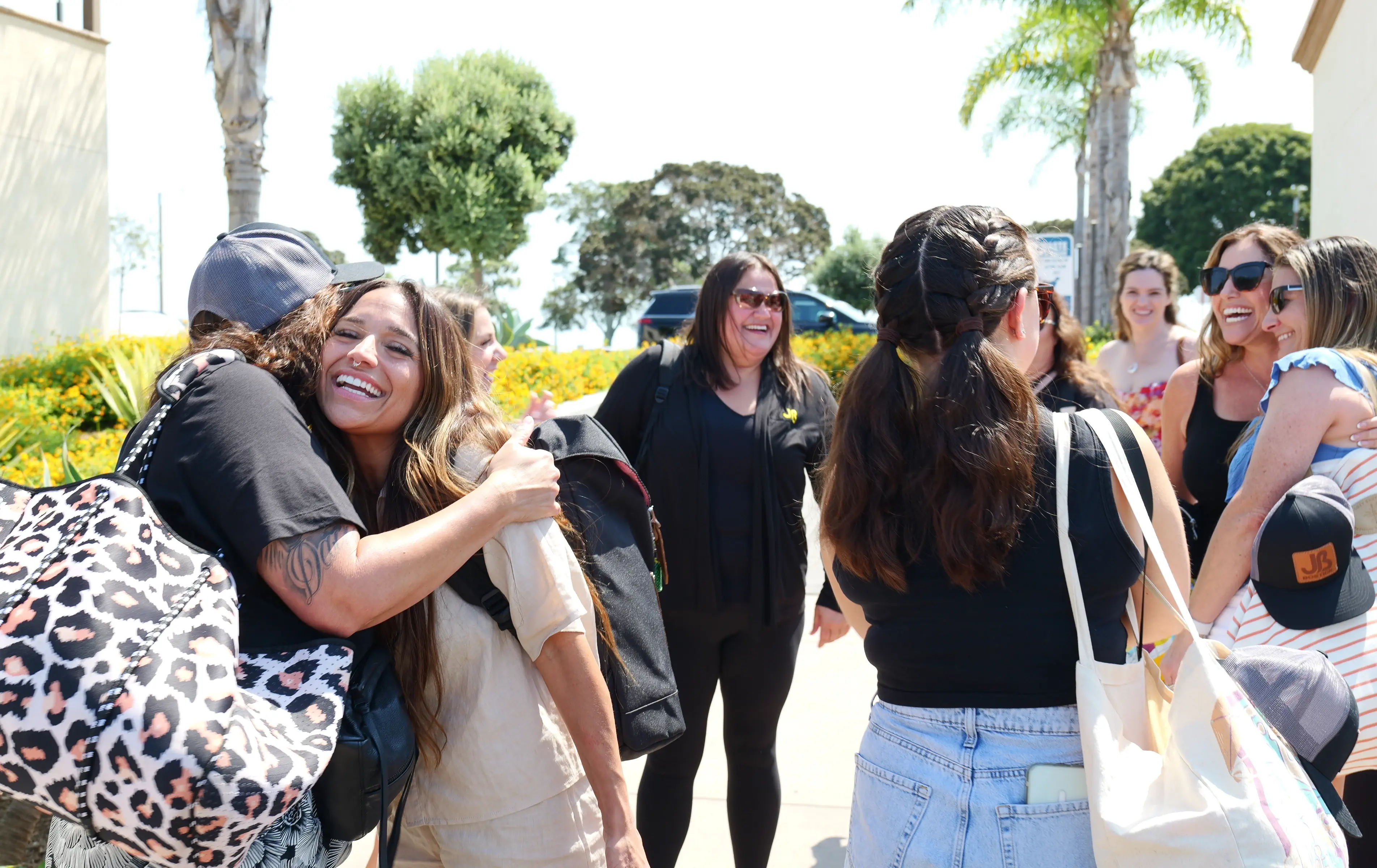 Diverse team of happy office employees hugging and smiling