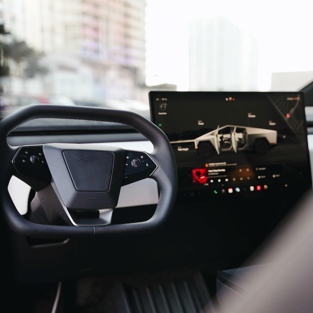 Driver’s cockpit view of the Cybertruck Cyberbeast, showing steering wheel, controls, and digital dashboard.